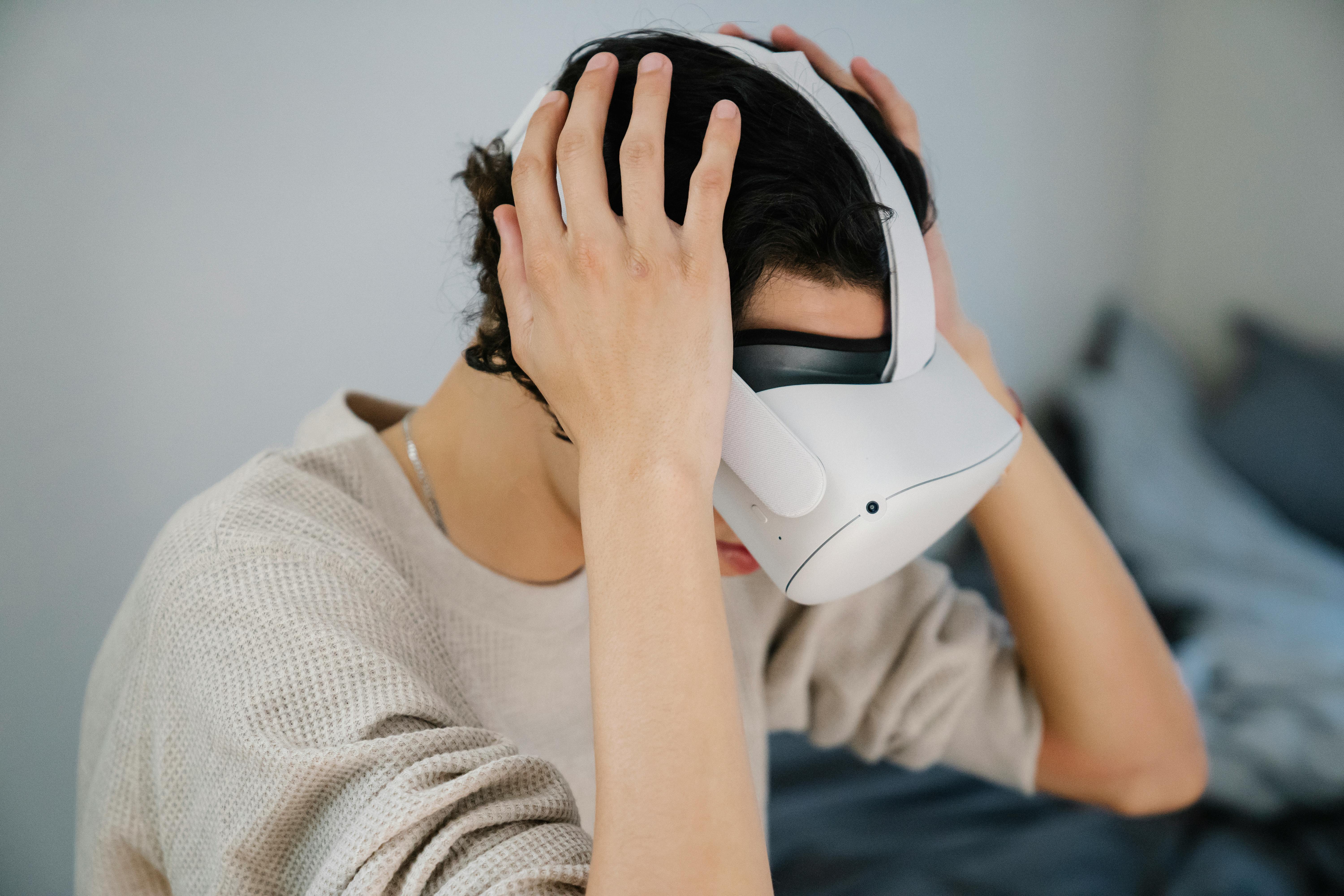 A young man wearing a VR headset, immersed in a digital experience indoors.