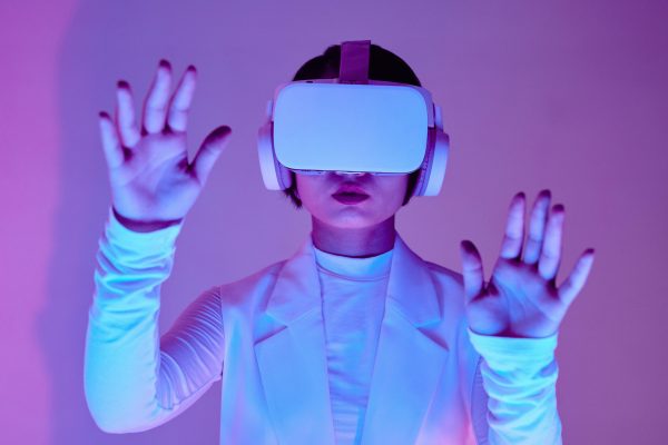 Woman in white long sleeves using virtual reality headset in a conceptual studio shoot.