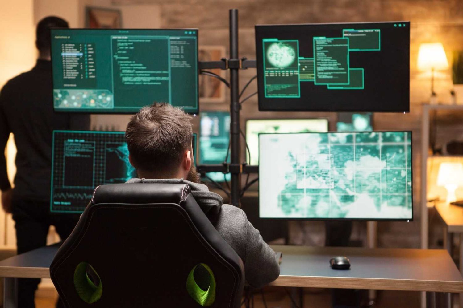 rear-view-of-hacker-in-front-of-computer-with-multiple-screens.jpg